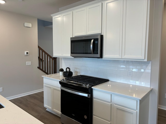 kitchen featuring stainless steel appliances, backsplash, dark wood-style floors, and white cabinets