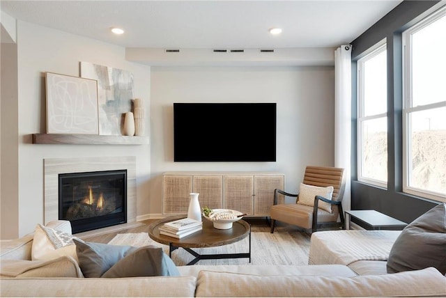 living room featuring visible vents, plenty of natural light, and wood finished floors