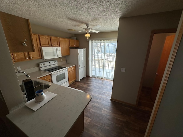 kitchen featuring ceiling fan, light countertops, dark wood-style floors, white appliances, and a sink