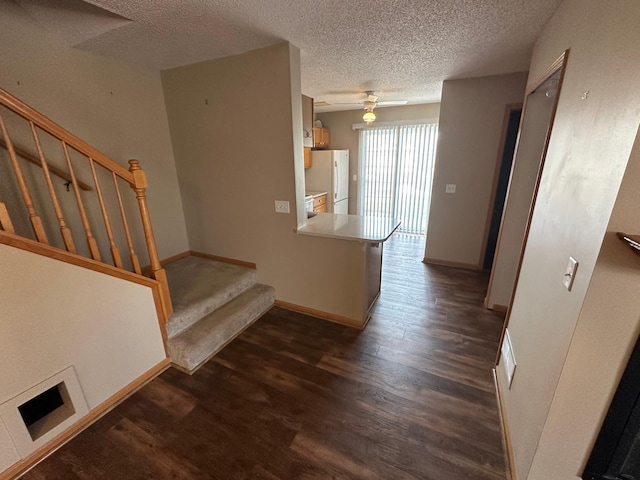 stairs with visible vents, baseboards, a textured ceiling, and wood finished floors