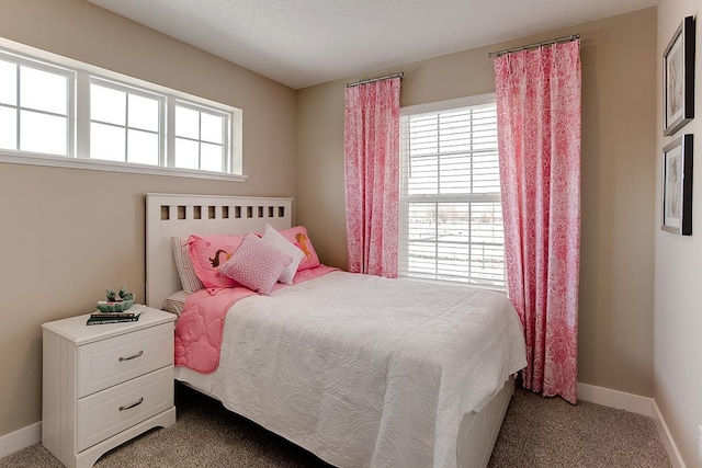 bedroom featuring carpet floors, multiple windows, and baseboards