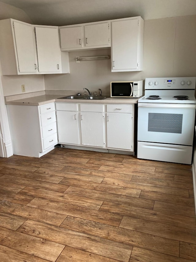 kitchen featuring white appliances, white cabinetry, a sink, and wood finished floors