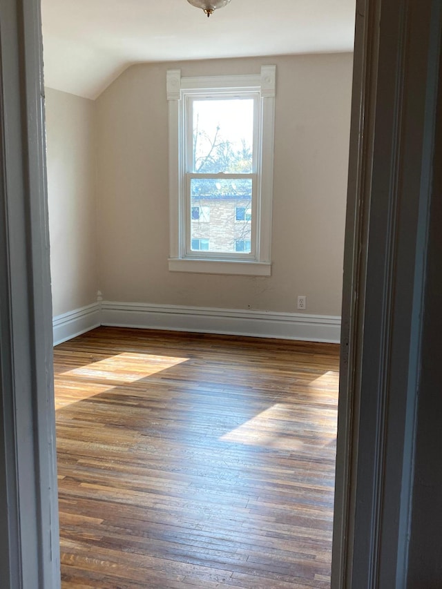 bonus room featuring lofted ceiling, baseboards, and dark wood finished floors