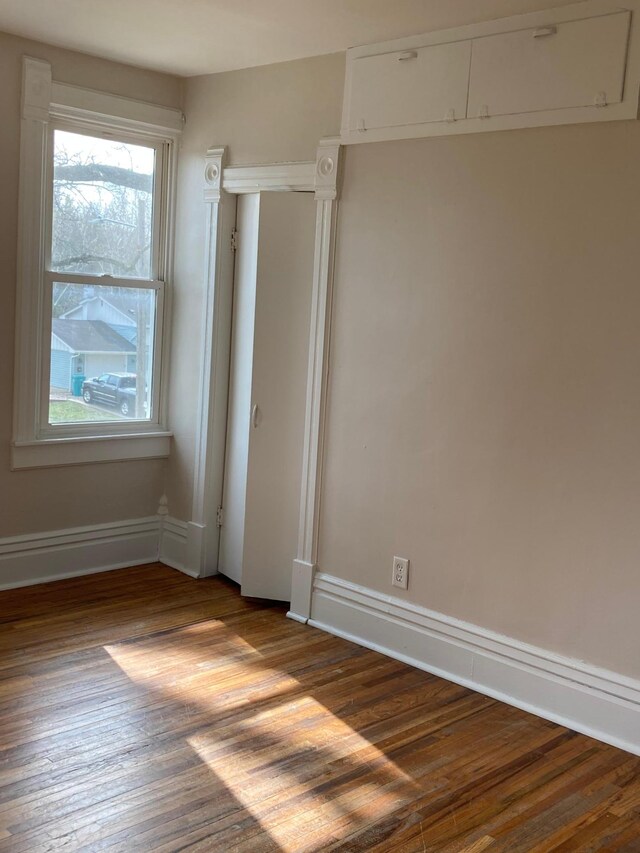 unfurnished bedroom with baseboards and wood finished floors