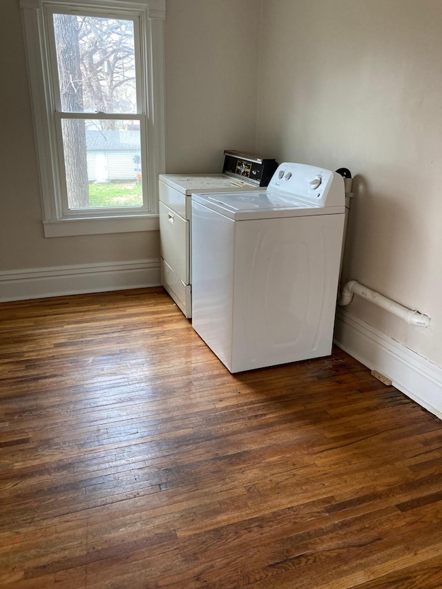 washroom with laundry area, baseboards, wood finished floors, and washing machine and clothes dryer