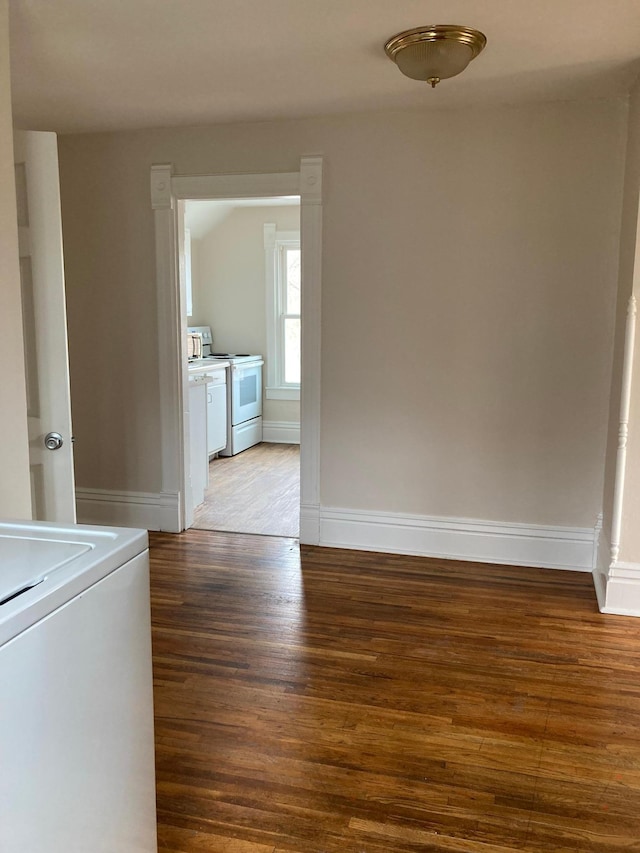 unfurnished room with washer / clothes dryer, baseboards, and wood finished floors