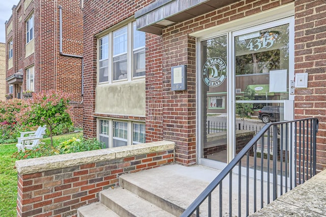 doorway to property featuring brick siding