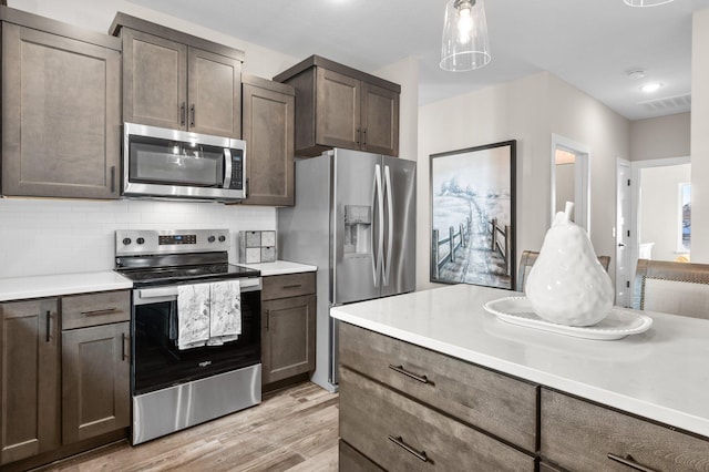 kitchen with stainless steel appliances, light countertops, visible vents, and backsplash