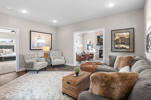 living area with recessed lighting, dark wood-style flooring, a fireplace, and baseboards