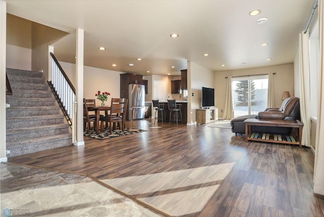 living room with dark wood-style floors, stairway, and recessed lighting