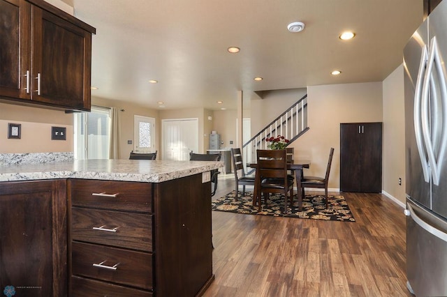 kitchen with dark wood-style flooring, recessed lighting, light countertops, freestanding refrigerator, and dark brown cabinets