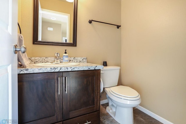 half bath featuring toilet, tile patterned flooring, vanity, and baseboards