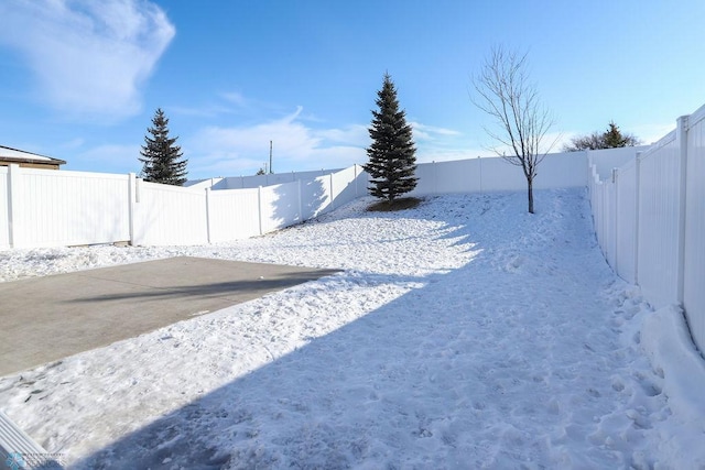 yard covered in snow with a fenced backyard