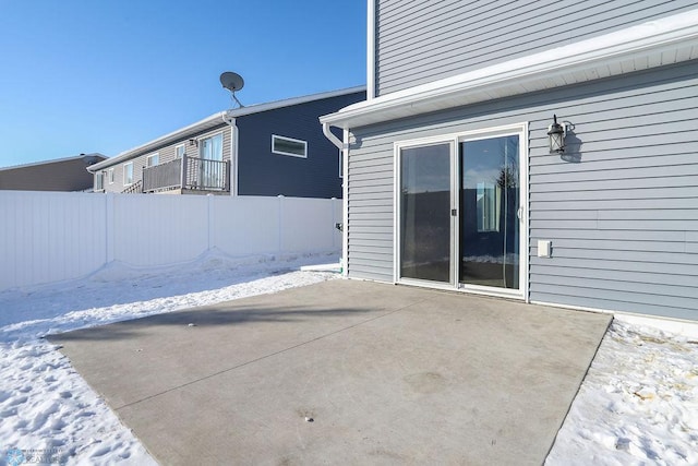 snow covered patio featuring fence