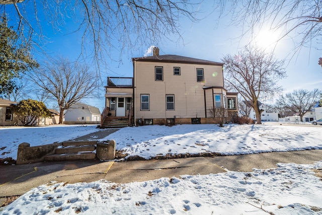 snow covered property featuring a chimney