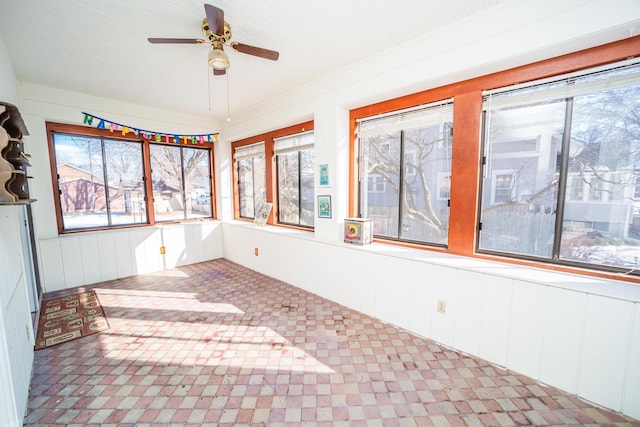 unfurnished sunroom with plenty of natural light and a ceiling fan