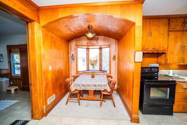 dining area featuring arched walkways, vaulted ceiling, and a healthy amount of sunlight