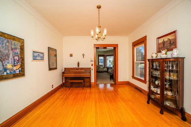 hall with ornamental molding, wood finished floors, visible vents, and baseboards