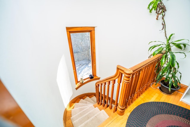 staircase featuring wood finished floors and baseboards