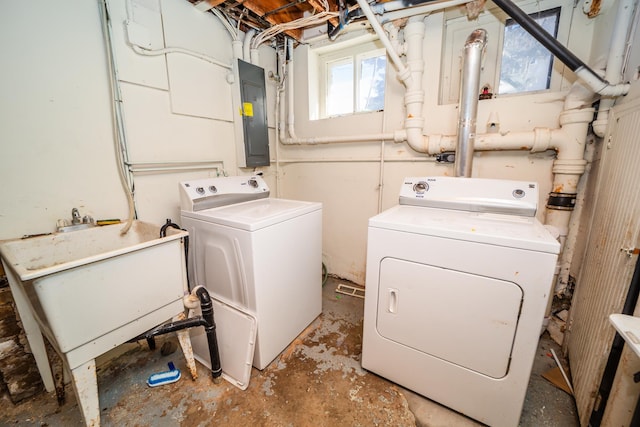 clothes washing area featuring a sink, laundry area, electric panel, and washer and dryer