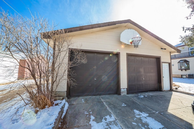 snow covered garage featuring a garage