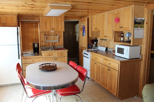 kitchen with white appliances, wood ceiling, light floors, and a sink