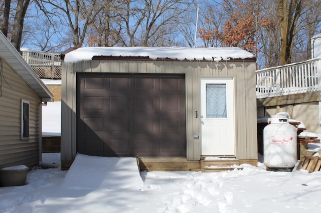 snow covered structure with an outbuilding