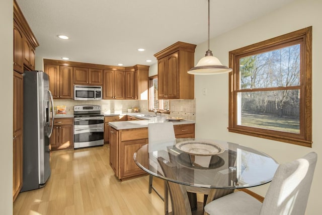 kitchen with backsplash, plenty of natural light, stainless steel appliances, and light countertops