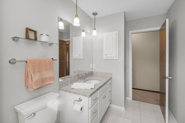 bathroom with toilet, tile patterned flooring, baseboards, and vanity