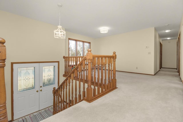 interior space featuring an inviting chandelier, carpet flooring, and baseboards