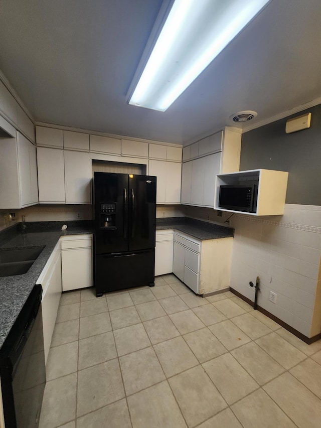 kitchen featuring dark countertops, black fridge with ice dispenser, white cabinets, a sink, and dishwashing machine