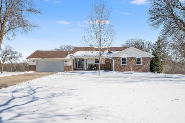 ranch-style house with an attached garage, driveway, and brick siding