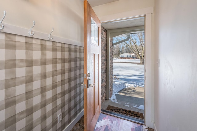 doorway featuring baseboards