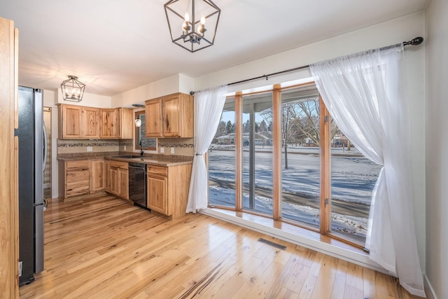 kitchen featuring dishwasher, a chandelier, decorative light fixtures, and freestanding refrigerator