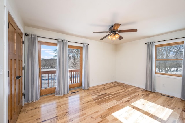 spare room featuring a healthy amount of sunlight, light wood finished floors, baseboards, and visible vents