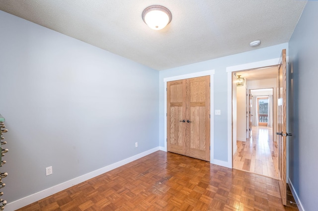 unfurnished bedroom with a closet, baseboards, and a textured ceiling