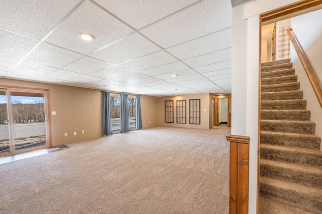 interior space featuring carpet floors, stairs, and a drop ceiling