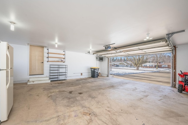 garage with freestanding refrigerator and a garage door opener