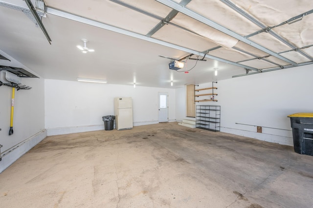 garage with a garage door opener and freestanding refrigerator