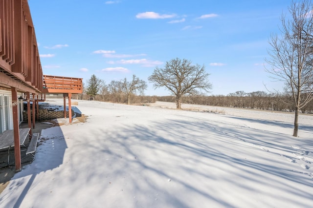 yard covered in snow featuring a wooden deck