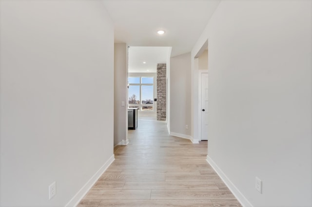 hallway featuring recessed lighting, baseboards, and light wood finished floors