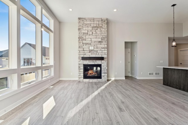 unfurnished living room featuring a fireplace, recessed lighting, visible vents, light wood-style flooring, and baseboards