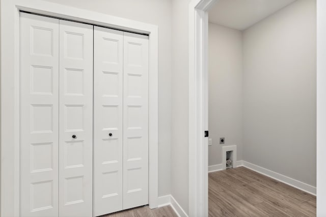 laundry area with light wood-type flooring, laundry area, electric dryer hookup, and baseboards