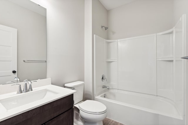 full bath featuring wood finished floors, shower / washtub combination, vanity, and toilet