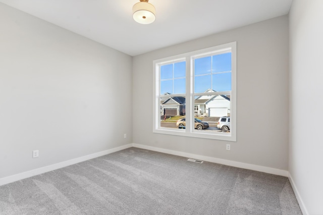 carpeted empty room with visible vents and baseboards