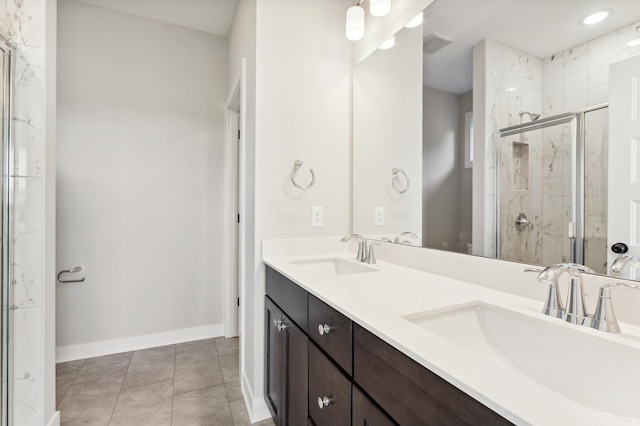 bathroom featuring double vanity, tile patterned flooring, a sink, and a marble finish shower