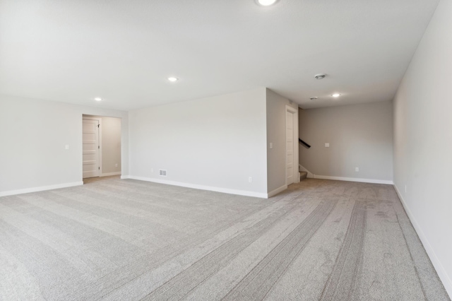 unfurnished room featuring stairs, recessed lighting, light colored carpet, and baseboards