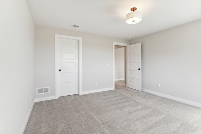 unfurnished bedroom with baseboards, visible vents, and light colored carpet