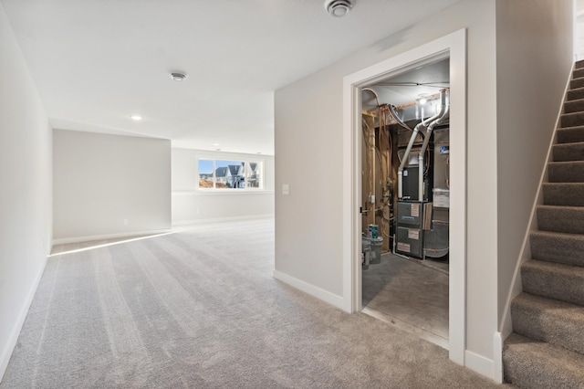 basement featuring heating unit, baseboards, stairway, and carpet flooring