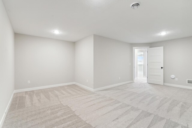 empty room with recessed lighting, light colored carpet, visible vents, and baseboards